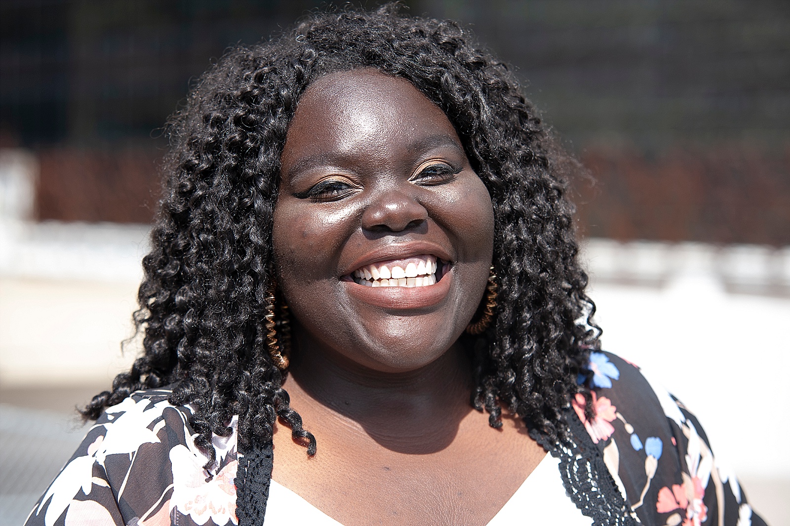 Smiling Black woman looks away from camera.