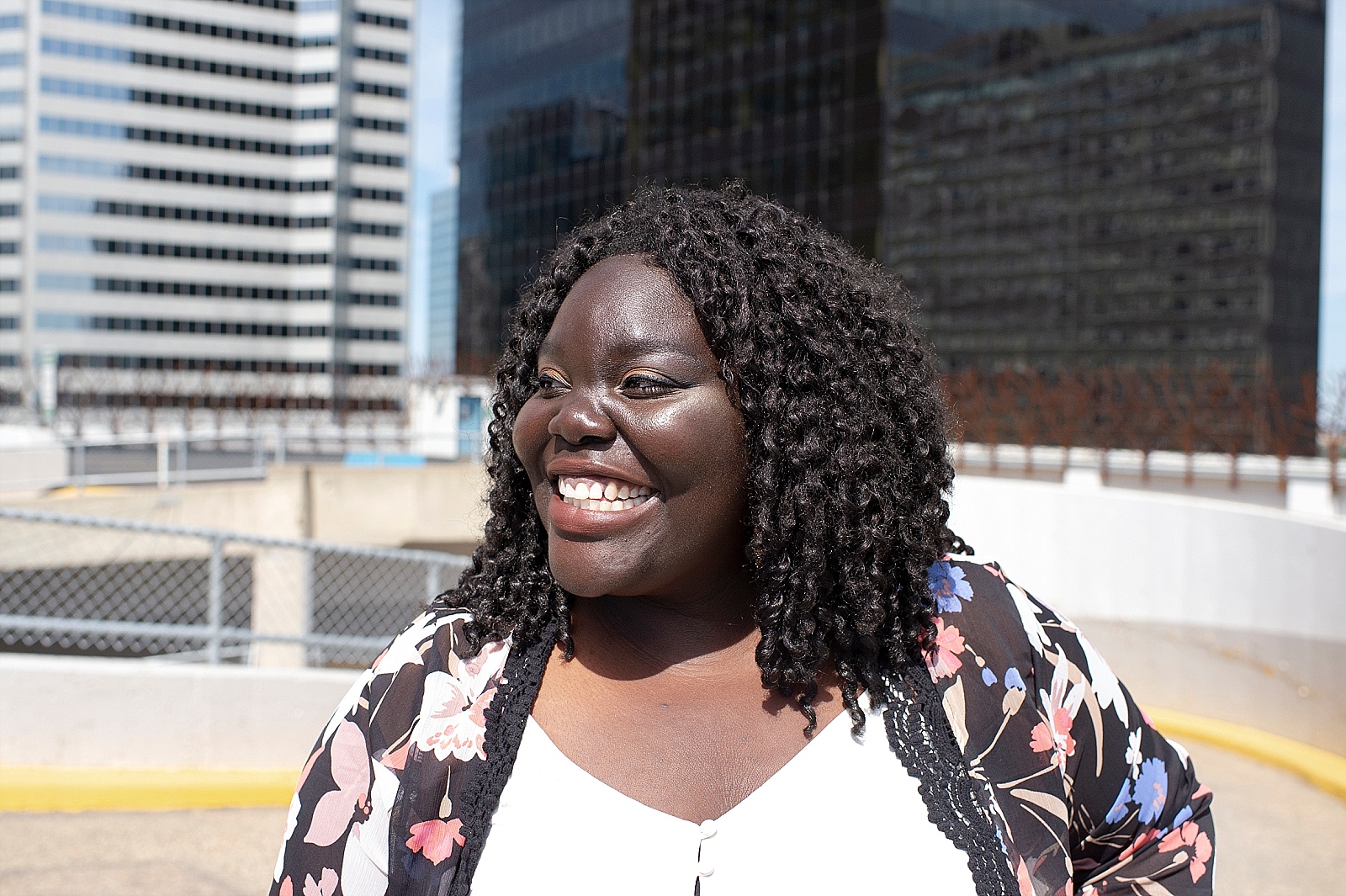 Smiling Black woman looks away from camera.